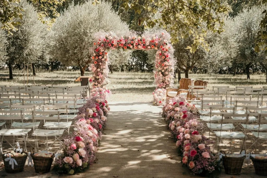 Allée de cérémonie fleurie de roses sous les oliviers