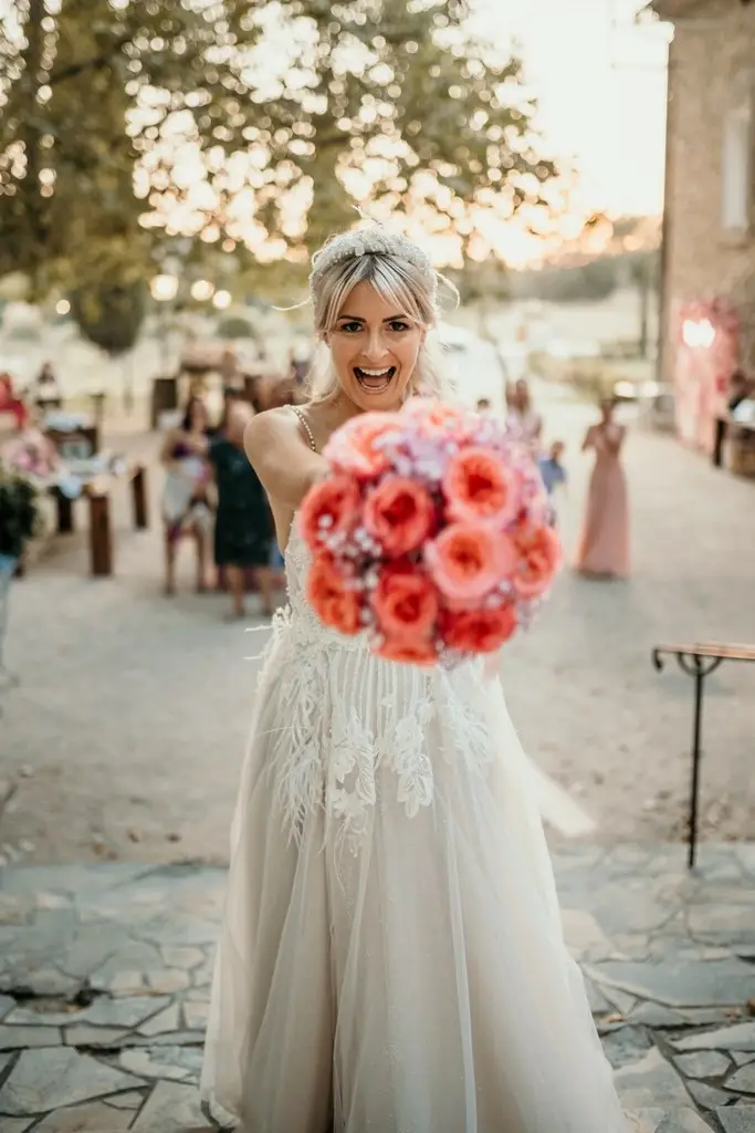 La mariée brandit joyeusement son bouquet