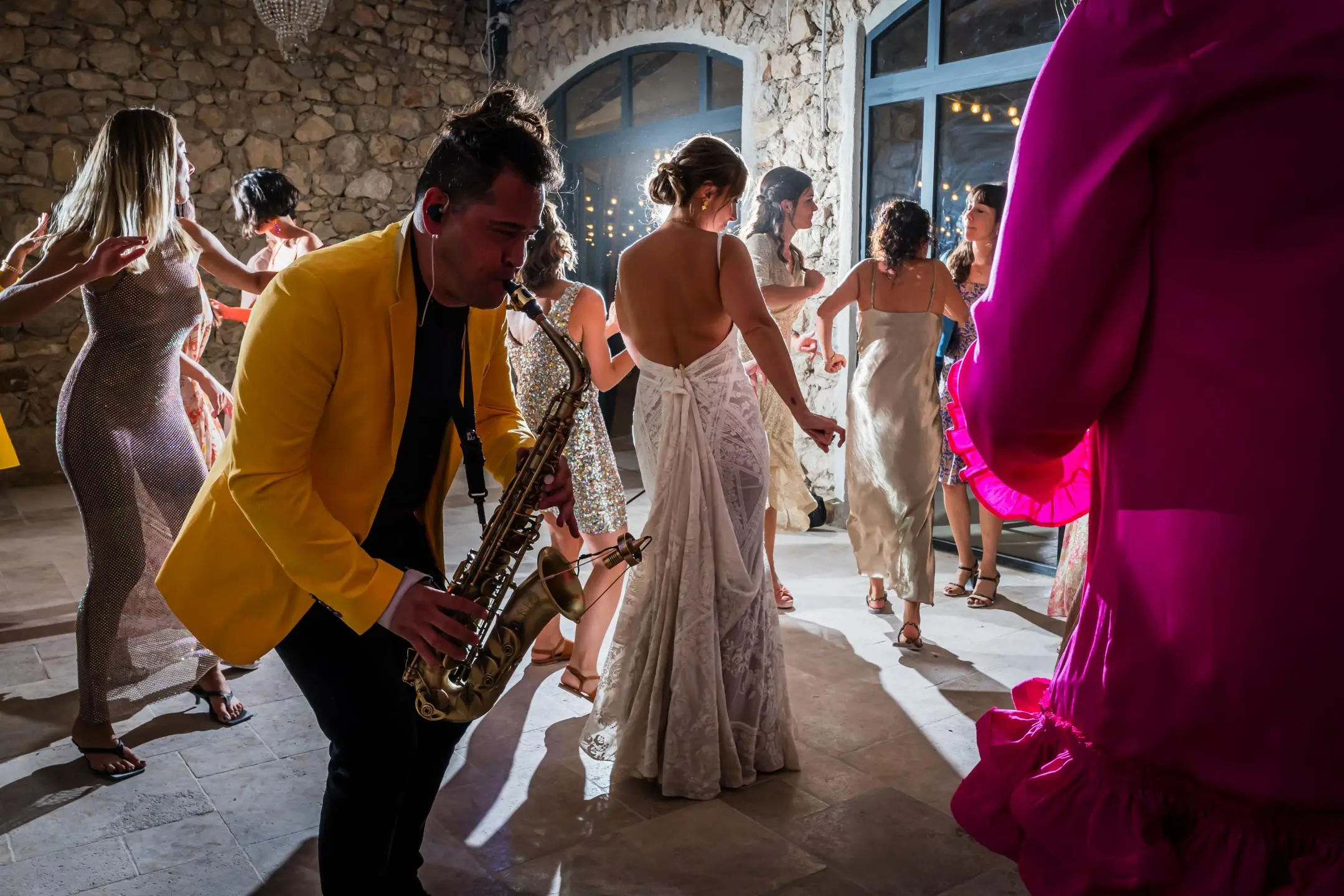 Un saxophoniste joue au milieu des invités pendant la soirée
