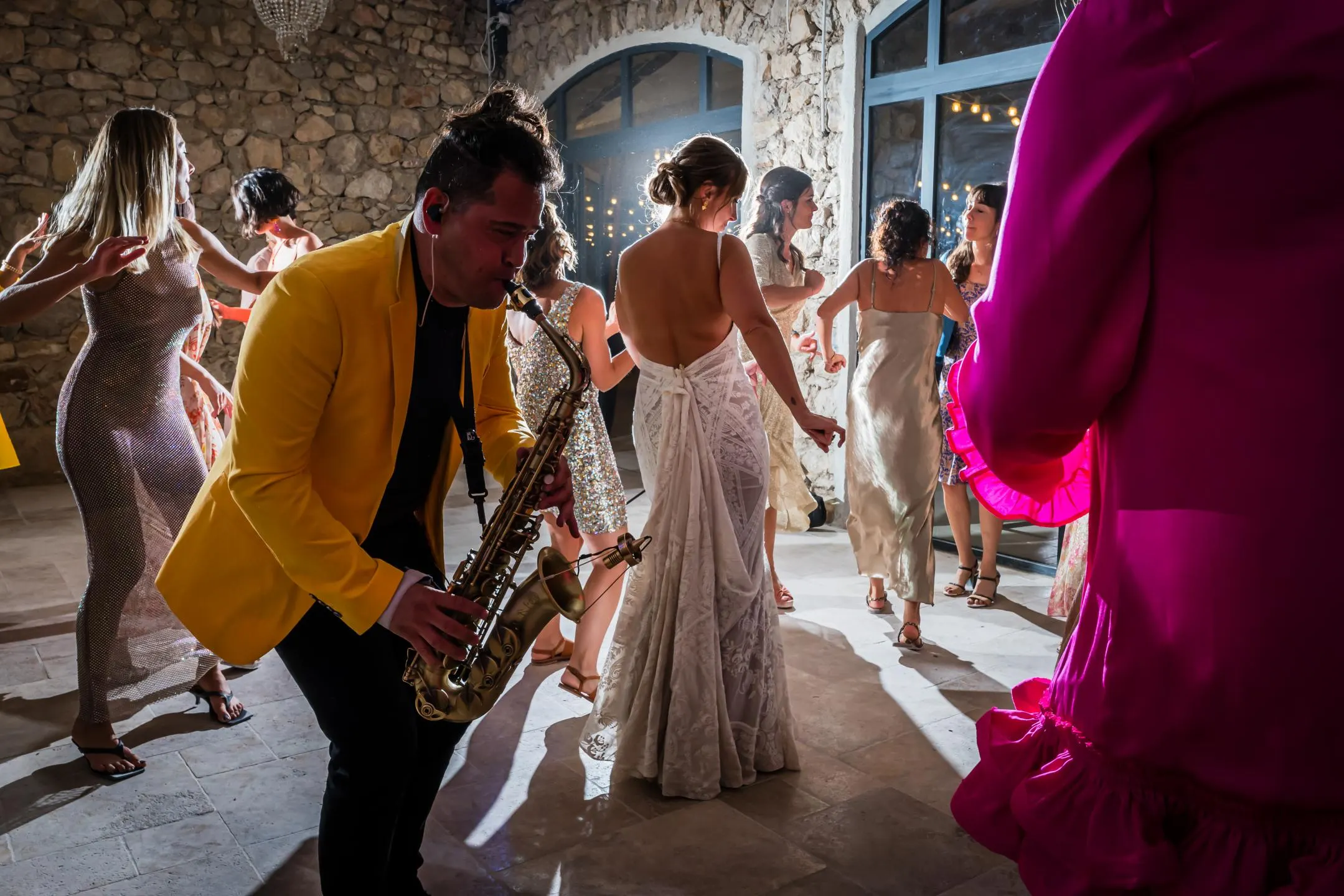 Un saxophoniste joue au milieu des invités pendant la soirée