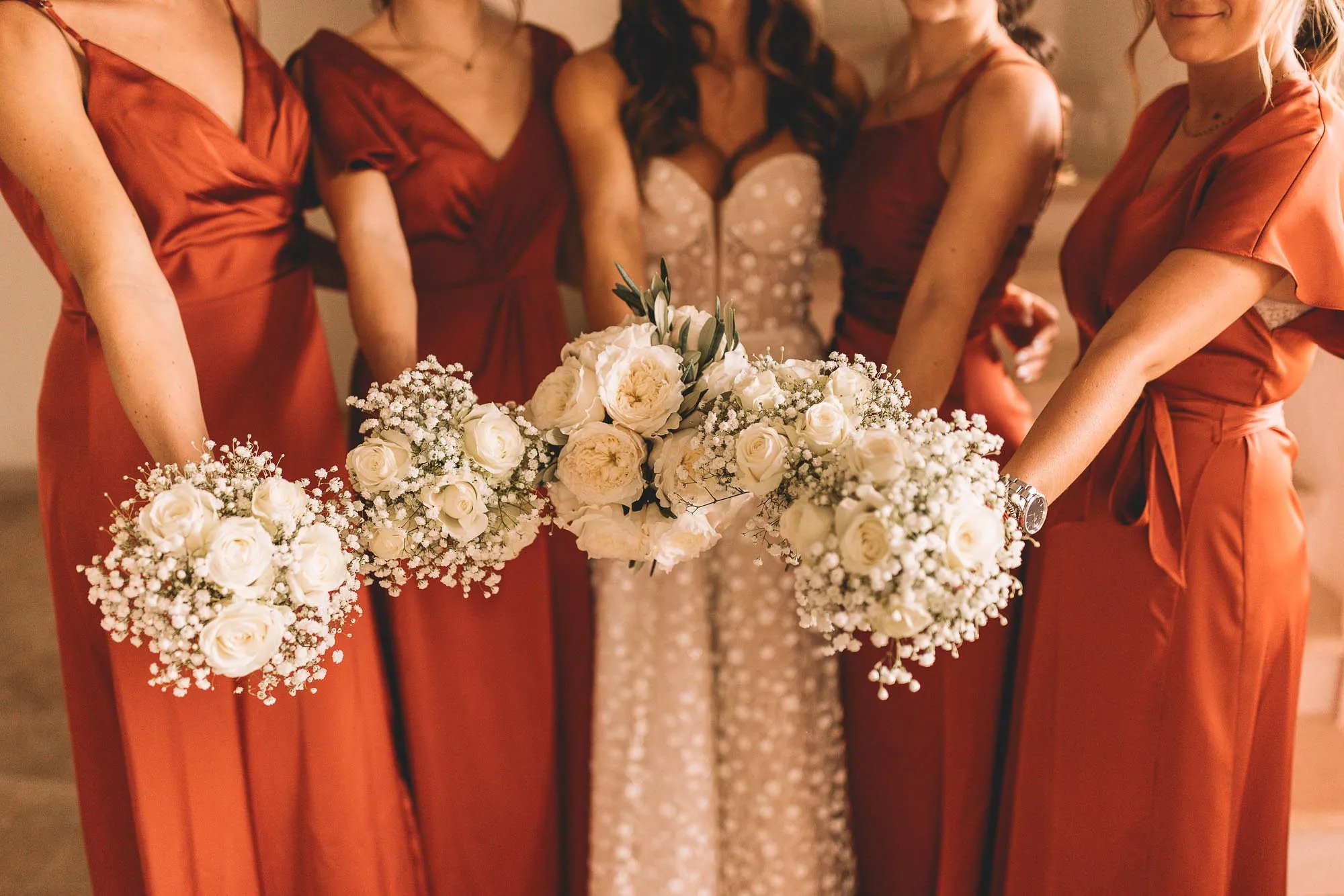 Demoiselles d’honneur en robes terracotta, bouquets à la main