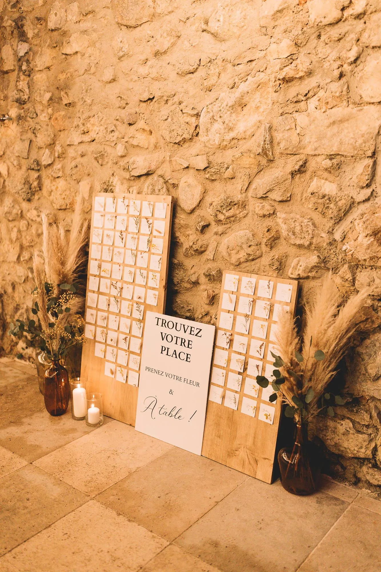 Le plan de table calligraphié contre le mur de pierre