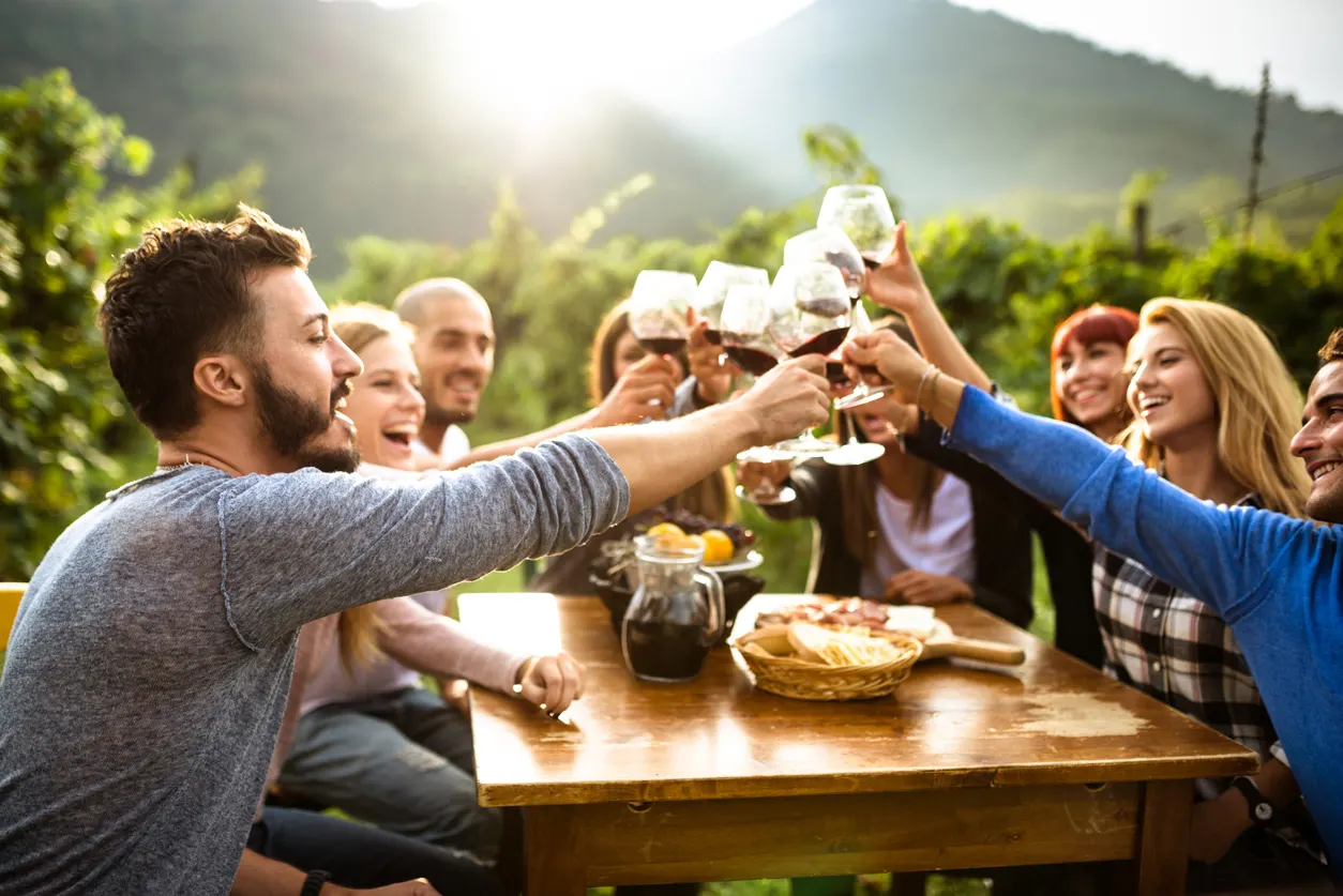 Une équipe trinque au soleil dans les vignes après une journée de travail